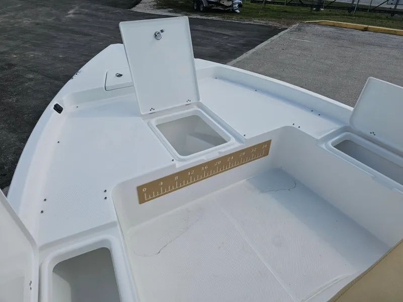 Slide: The Image of 2025 Savannah 210X boat deck with storage compartments and measuring ruler. - 24