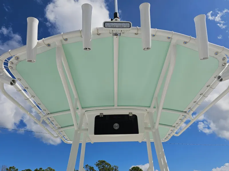 Slide: The Image of Savannah 210X 2025 boat canopy with rod holders against blue sky. - 25