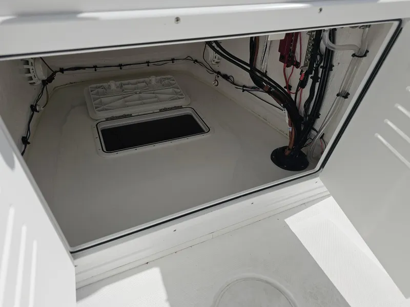 Slide: The Image of Interior compartment of 2025 Savannah 210X boat, showcasing wiring and storage space. - 26