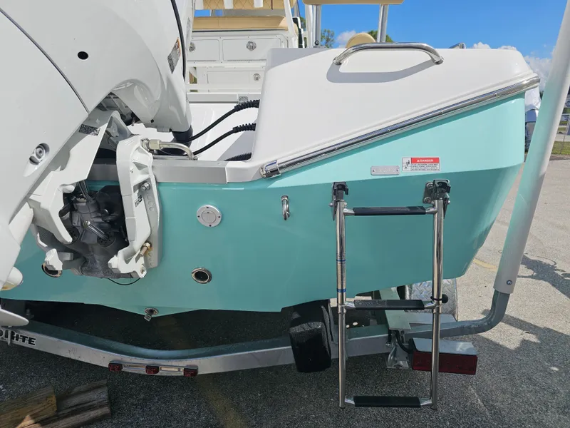 Slide: The Image of 2025 Savannah 210X boat stern with ladder and outboard motor on trailer. - 30