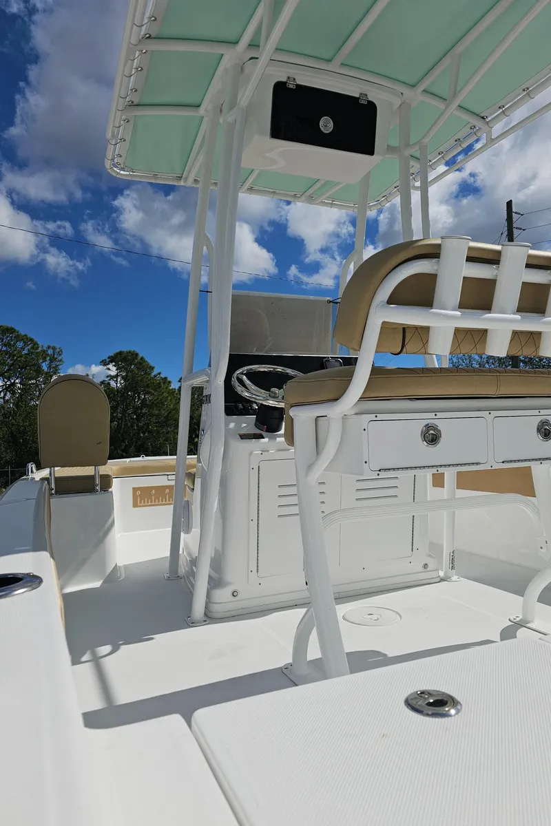 Slide: The Image of 2025 Savannah 210X boat interior with seating and console under a clear blue sky. - 32