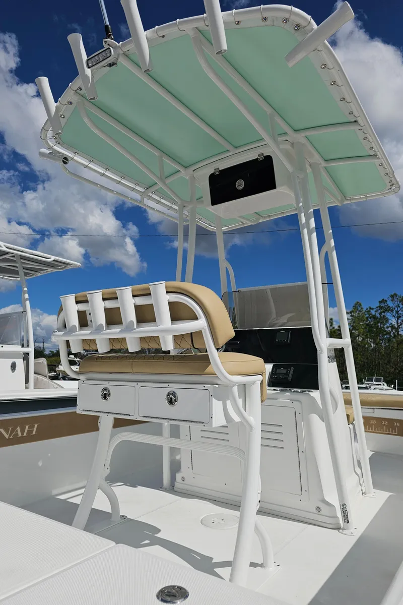 Slide: The Image of 2025 Savannah 210X boat with T-top and seating, under a clear blue sky. - 8