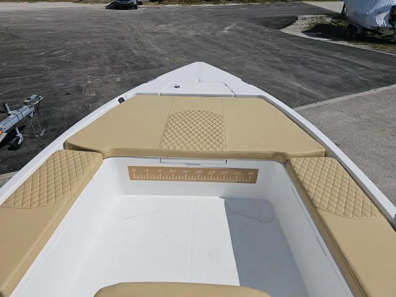 Slide: The Image of 2025 Savannah 210X boat interior with tan cushioned seating and measuring ruler. - 9