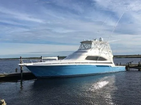 Slide: The Image of 2007 Bertram 570 Convertible yacht docked on calm water under a clear sky. - 18