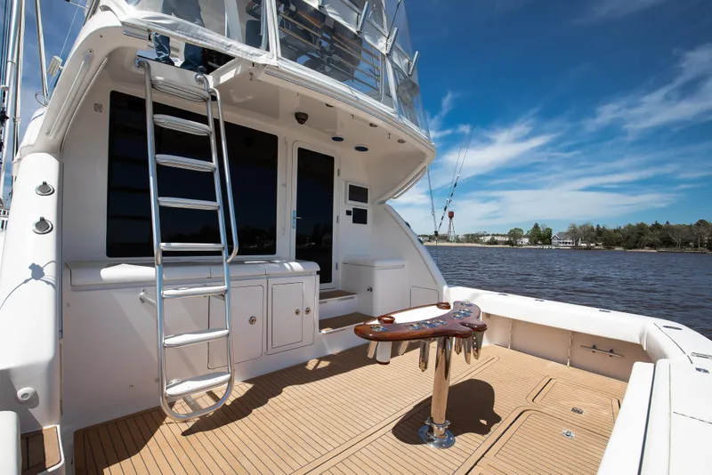 Slide: The Image of 2007 Bertram 570 Convertible yacht deck with ladder and fishing table, under clear blue sky. - 22