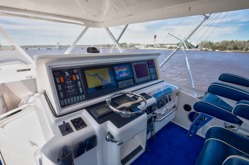 Slide: The Image of 2007 Bertram 570 Convertible yacht helm with navigation screens and blue seating. - 25