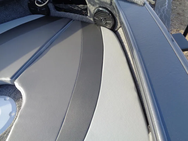 Slide: The Image of 2025 Lund 1875 Crossover XS boat interior with gray seating and speaker. - 13