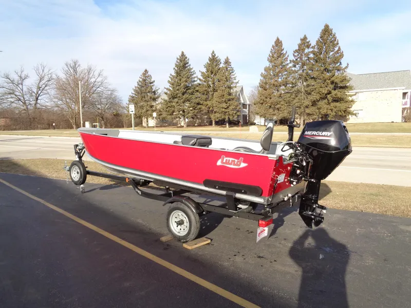The Image of 2025 Lund 1600 Fury Heritage boat on trailer, red exterior, parked outdoors. - 1