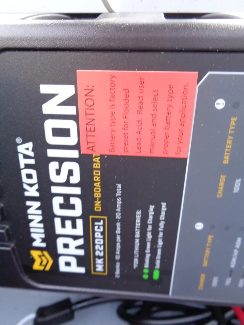 Slide: The Image of Minn Kota Precision MK220PCL on-board battery charger with attention label, 2025 Lund 1600 Fury Heritage. - 13