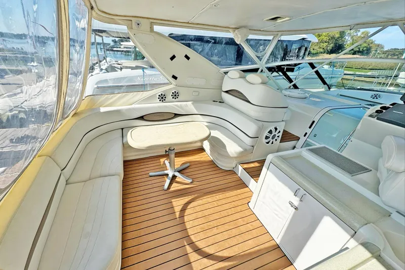 Slide: The Image of 1998 Trojan 440 Express yacht interior with white seating and wooden flooring. - 11