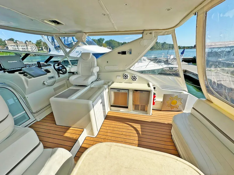 Slide: The Image of 1998 Trojan 440 Express yacht interior with white seating and wooden flooring. - 12