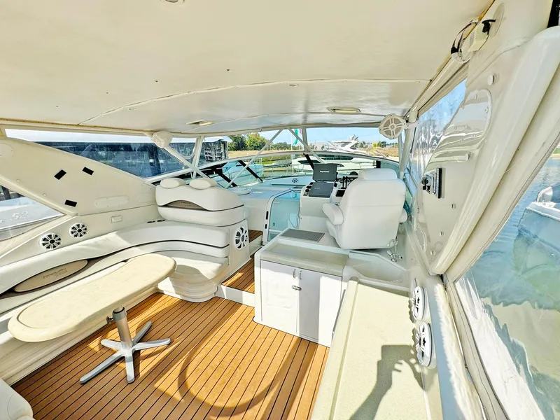 Slide: The Image of 1998 Trojan 440 Express yacht interior with seating, table, and helm, featuring sleek design and wood flooring. - 14