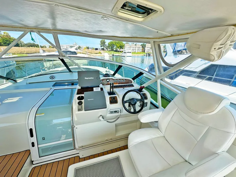 Slide: The Image of 1998 Trojan 440 Express yacht cockpit with steering wheel, navigation equipment, and white captain's chair. - 18