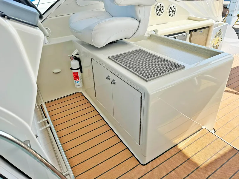 Slide: The Image of 1998 Trojan 440 Express yacht interior with seating, storage, and fire extinguisher on teak deck. - 19