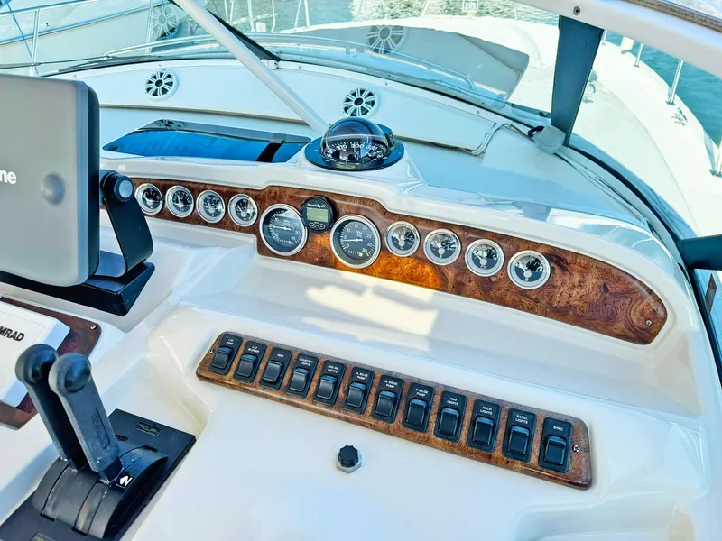Slide: The Image of 1998 Trojan 440 Express yacht dashboard with gauges and controls, featuring a wood finish. - 20