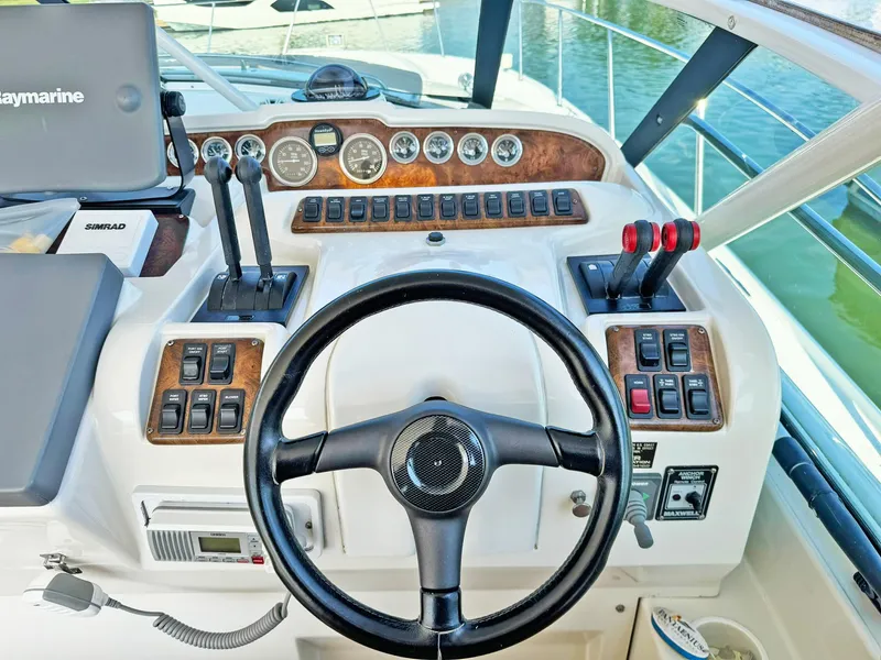 Slide: The Image of Control panel of a 1998 Trojan 440 Express boat with steering wheel and gauges. - 22