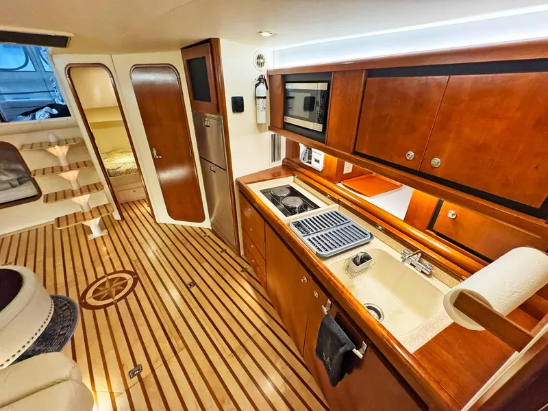 Slide: The Image of Luxurious 1998 Trojan 440 Express yacht interior with modern kitchen and wooden flooring. - 27