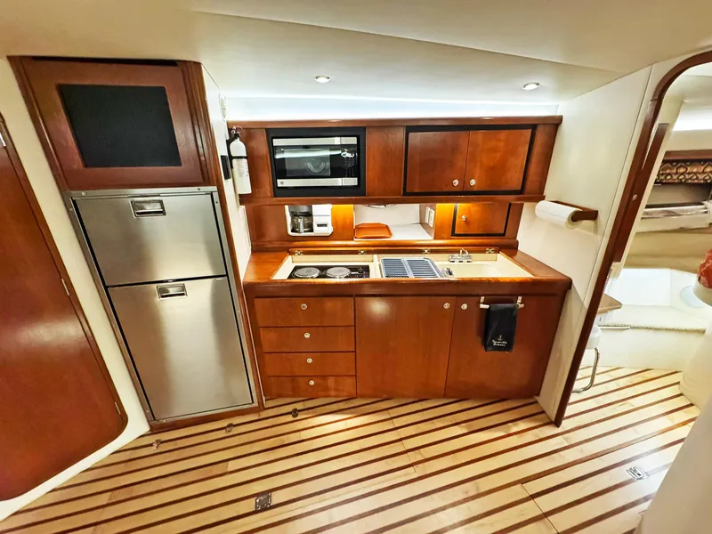 Slide: The Image of Luxurious 1998 Trojan 440 Express yacht kitchen with wood cabinetry and modern appliances. - 28