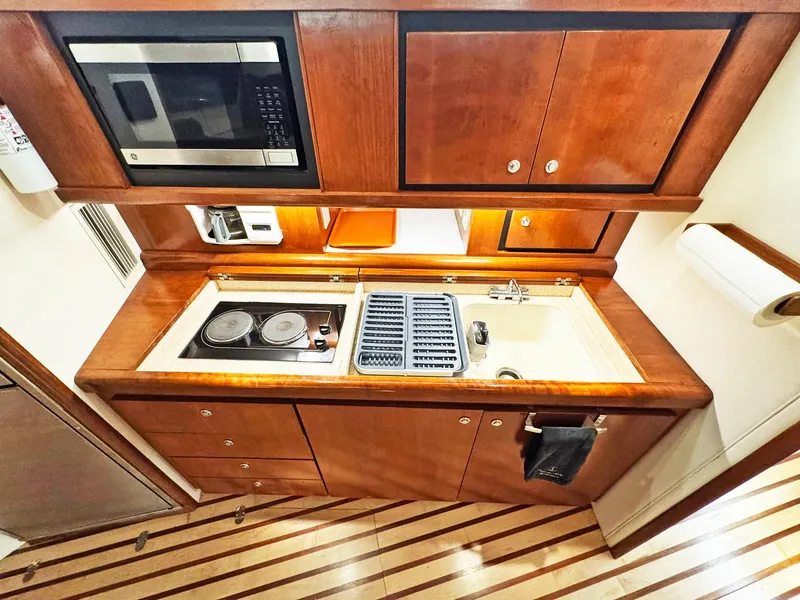 Slide: The Image of Kitchen area of a 1998 Trojan 440 Express yacht with stove, sink, and microwave. - 29