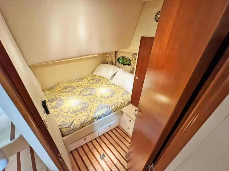 Slide: The Image of 1998 Trojan 440 Express cabin with cozy bed, wooden flooring, and storage drawers. - 31