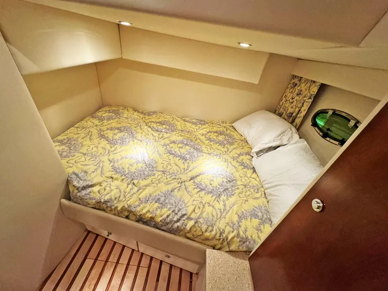 Slide: The Image of Cozy cabin interior of 1998 Trojan 440 Express with patterned bedding and wooden flooring. - 32