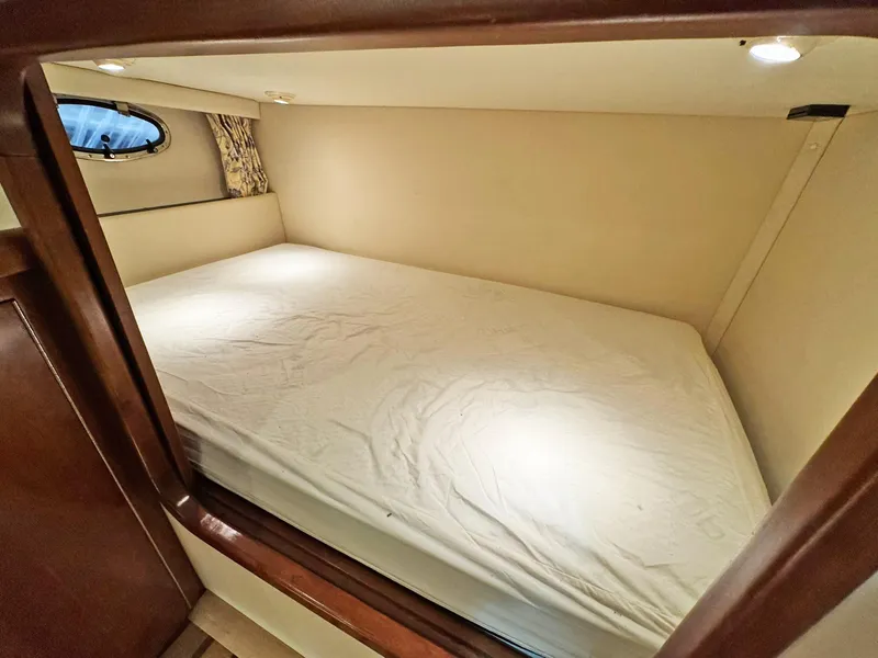Slide: The Image of 1998 Trojan 440 Express cabin interior with bed, soft lighting, and porthole window. - 35