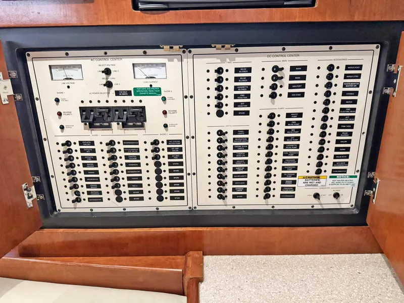 Slide: The Image of Electrical control panel on a 1998 Trojan 440 Express boat, featuring switches and meters. - 37