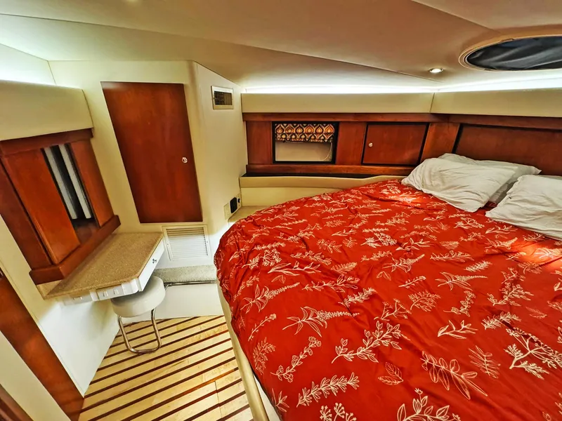 Slide: The Image of Luxurious cabin interior of 1998 Trojan 440 Express with red bedding and wooden accents. - 40