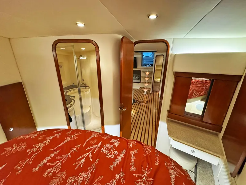 Slide: The Image of Luxurious 1998 Trojan 440 Express yacht interior with elegant wood finishes and cozy bedroom. - 42
