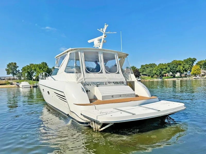 Slide: The Image of 1998 Trojan 440 Express yacht on calm water, clear sky, rear view. - 6