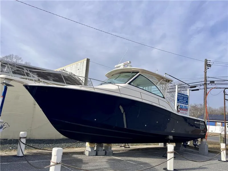Slide: The Image of 2015 Grady-White Express 370 boat on display, elevated on supports, with a sleek design. - 1