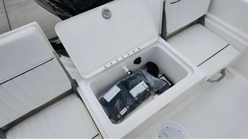Slide: The Image of Bayliner T18 Limited Edition 2025 boat storage compartment with open lid and packaged items inside. - 17