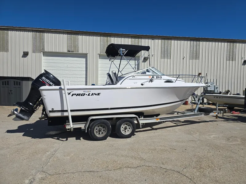 Slide: The Image of 2007 Pro-Line 21 Walkaround boat on trailer, parked outdoors, with Suzuki outboard motor. - 5