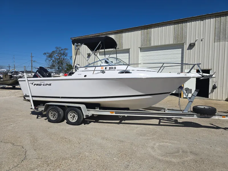 Slide: The Image of 2007 Pro-Line 21 Walkaround boat on trailer, parked outside a warehouse. - 6