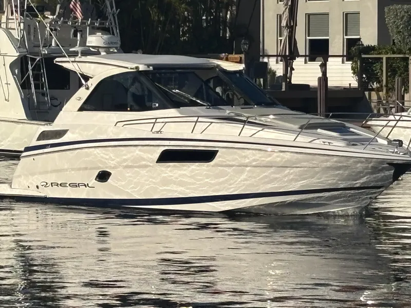 Slide: The Image of 2015 Regal 35 Sport Coupe yacht docked on calm water. - 0