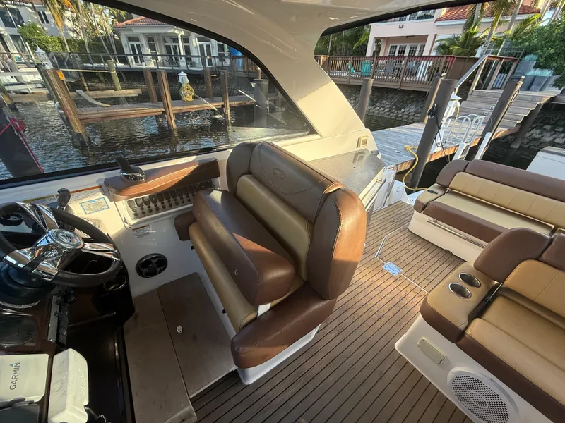 Slide: The Image of 2015 Regal 35 Sport Coupe interior with brown leather seating and waterfront view. - 11
