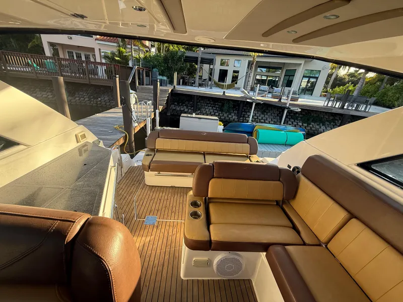 Slide: The Image of Luxurious 2015 Regal 35 Sport Coupe yacht interior with plush seating and wooden deck. - 12