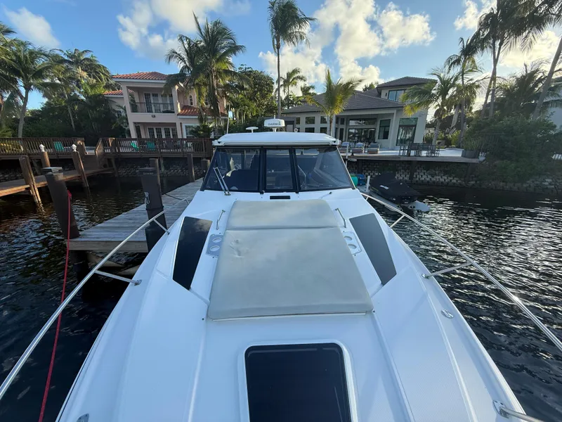 Slide: The Image of 2015 Regal 35 Sport Coupe docked by waterfront homes, surrounded by palm trees. - 5