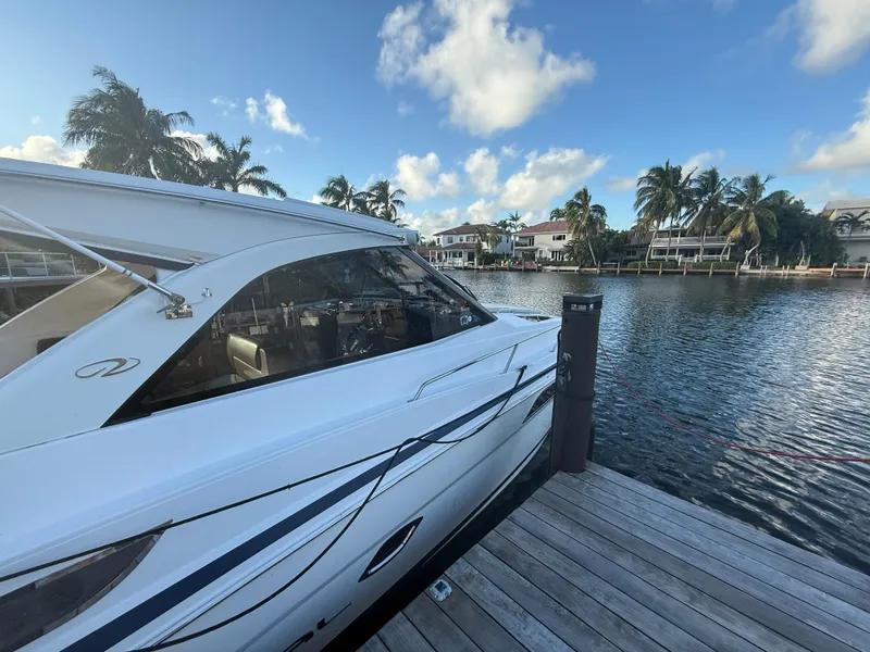 Slide: The Image of 2015 Regal 35 Sport Coupe docked by a scenic waterfront with palm trees. - 7