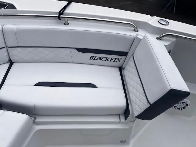 Slide: The Image of 2021 Blackfin 252 CC boat interior with white cushioned seating and logo. - 14