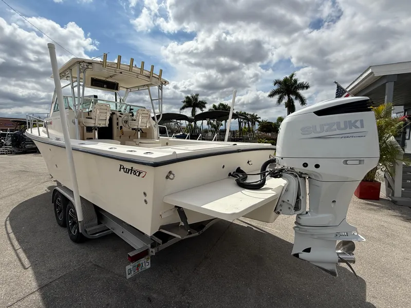 Slide: The Image of 2005 Parker 2510 Deep Vee Walkaround boat with Suzuki outboard motor, parked outdoors. - 10