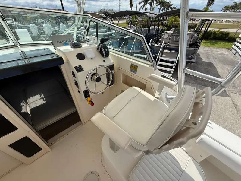 Slide: The Image of 2005 Parker 2510 Deep Vee Walkaround boat interior with captain's chair and steering console. - 14