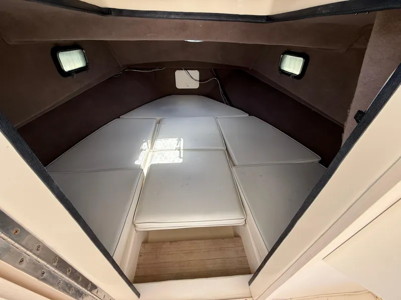 Slide: The Image of 2005 Parker 2510 Deep Vee Walkaround cabin interior with cushioned seating and small windows. - 16