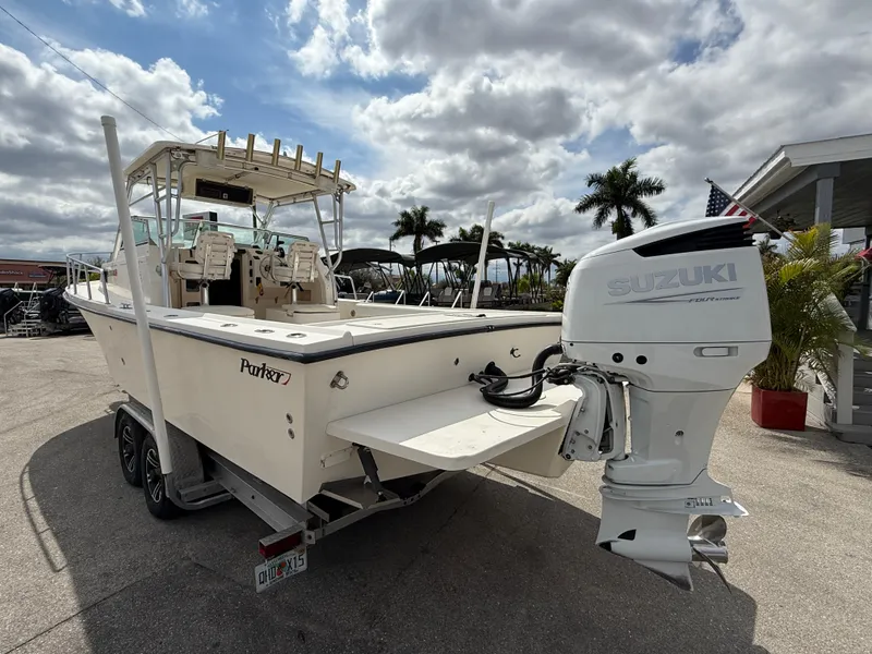 Slide: The Image of 2005 Parker 2510 Deep Vee Walkaround boat with Suzuki outboard motor, parked outdoors. - 9