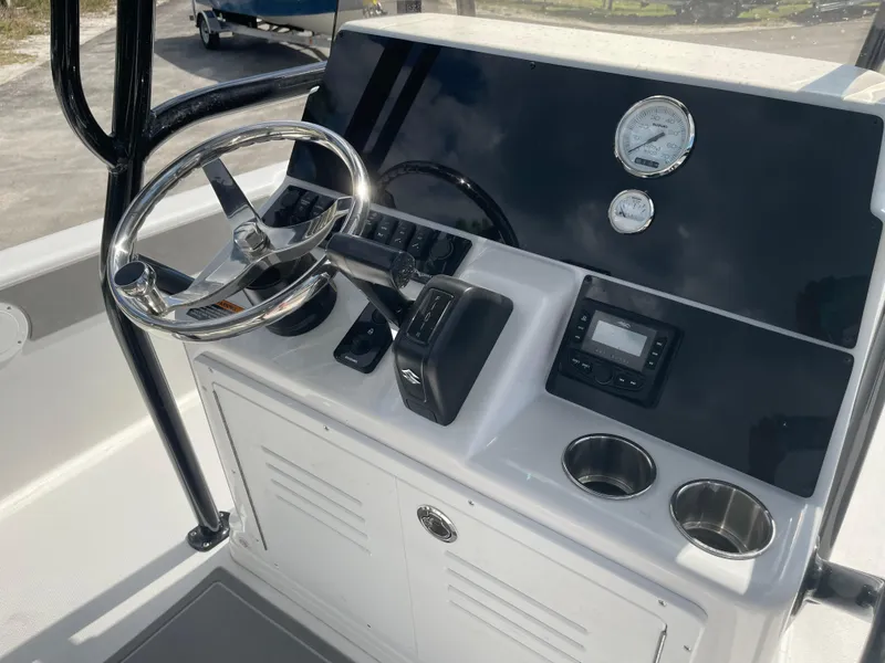 Slide: The Image of 2025 Savannah 210X boat console with steering wheel, gauges, and cup holders. - 20
