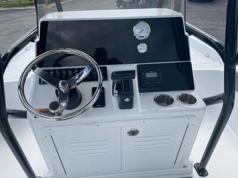 Slide: The Image of 2025 Savannah 210X boat console with steering wheel, gauges, and cup holders. - 4