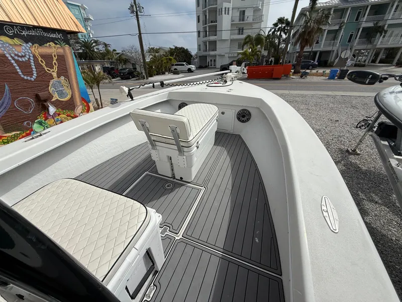 Slide: The Image of 2021 C-Hawk 25 Center Console boat with seating, docked near colorful mural and buildings. - 10