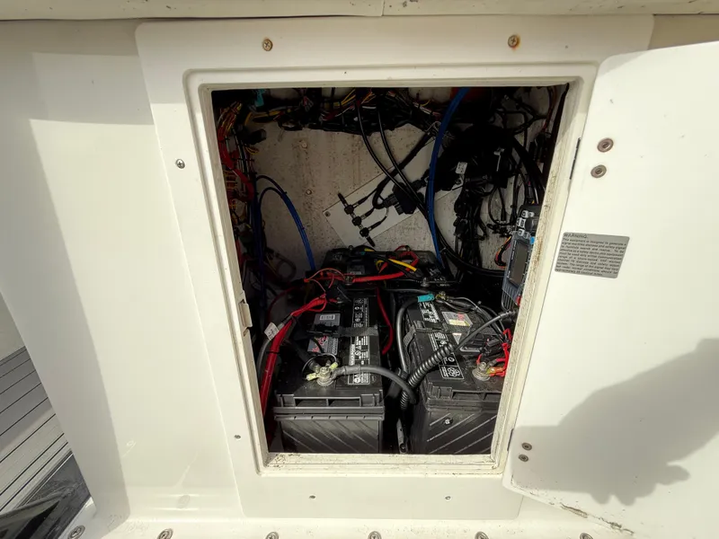 Slide: The Image of Battery compartment of a 2021 C-Hawk 25 Center Console boat, showing wiring and connections. - 12