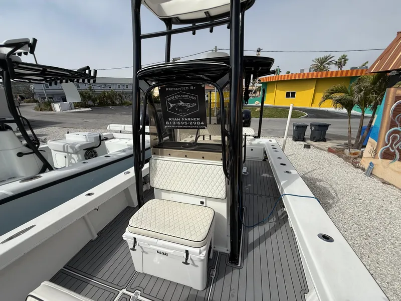 Slide: The Image of 2021 C-Hawk 25 Center Console boat with seating and storage, docked outdoors. - 13