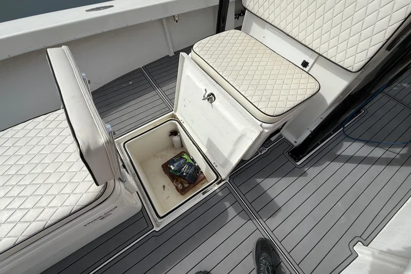 Slide: The Image of C-Hawk 25 Center Console 2021 boat interior with storage compartment and cushioned seats. - 18